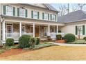 Charming front porch with stone accents, white railings, and a comfortable seating area overlooking the yard at 2290 Spencers Way, Stone Mountain, GA 30087