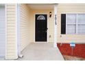 Close up showcasing black front door, stylish porch light, and fresh landscaping at 7015 Setters Way, Lithonia, GA 30038