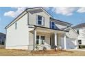 Two-story house with light brick and gray siding, a white two-car garage, and a front porch at 1569 High Falls Ln, Grayson, GA 30017