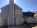 Rear view of a house showcasing gray siding, a chimney, and a back patio at 5332 Shirewick Dr, Lithonia, GA 30058