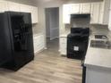 Kitchen with white cabinets, black appliances, and light gray countertops at 5332 Shirewick Dr, Lithonia, GA 30058