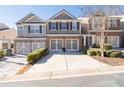 Exterior view of a modern townhome showcasing a long driveway, well-maintained landscaping, and neutral tones at 1584 Richmond Se Dr, Mableton, GA 30126