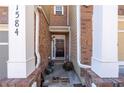 View of the front entrance with brick accents, decorative plants, and a welcoming door mat at 1584 Richmond Se Dr, Mableton, GA 30126