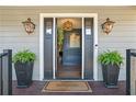 Welcoming entry with dark gray door, lanterns and potted plants at 3051 Maple Ln, Alpharetta, GA 30009