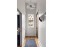 Bright hallway with hardwood floors, modern lighting, and a view of a charming house through the window at 122 Gainey Ln, Chattahoochee Hills, GA 30268