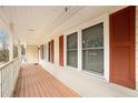 Covered porch with wooden railing and red shutters at 1836 Poinsetta Dr, Acworth, GA 30102