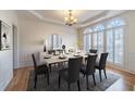 Elegant dining room featuring modern chandelier, shuttered windows, wainscoting, and large dining set at 3184 Islesworth Trce, Duluth, GA 30097