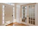 Bright foyer features hardwood floors, a paneled front door, and French doors leading to another room at 3184 Islesworth Trce, Duluth, GA 30097