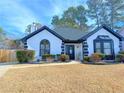 Ranch style home with a white exterior, black accents, and landscaping at 2270 Waterford Park Dr, Lawrenceville, GA 30044