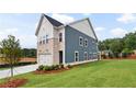 Striking two-story home showcasing blue siding, stone accents, a two-car garage, and manicured landscaping at 5756 Tillman Way, Powder Springs, GA 30127