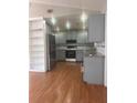 Bright kitchen features gray cabinetry, stainless steel appliances, recessed lighting, and wood flooring at 220 Canterbury Ln, Lawrenceville, GA 30046