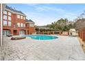 Kidney shaped pool with brick patio and outdoor fireplace at 2280 Wilshire Dr, Grayson, GA 30017