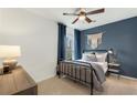 Bedroom with metal bed frame, blue accent wall, and ceiling fan at 5270 Birch Valley Rd, Cumming, GA 30028