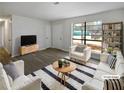 Virtually staged living room with modern furniture and large windows at 9129 Bent Pine Ne Ct, Covington, GA 30014