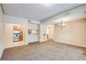 Spacious living room featuring neutral carpeting, open access to the kitchen, and modern chandelier lighting at 1250 Parkwood Se Cir # 1004, Atlanta, GA 30339
