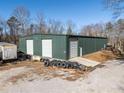 Large green metal building with three garage doors at 200 Heath Rd, Carrollton, GA 30116
