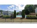 Community pool with fence, trees and playground equipment nearby at 152 Darbys Run Ct, Hiram, GA 30141