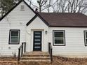 Charming home featuring white siding, a brick facade, a front door with windows, and a brown roof at 1706 Alvarado Sw Ter, Atlanta, GA 30310