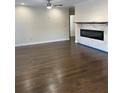 An open living area with hardwood floors, a ceiling fan, and a modern electric fireplace with tile surround at 1706 Alvarado Sw Ter, Atlanta, GA 30310