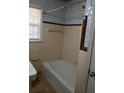 Retro bathroom with beige and brown tile, shower/tub combo, and window at 4985 Doby Ln, Austell, GA 30106