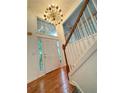 Bright entryway features wood floors, staircase, white trim, and modern chandelier at 571 Oak Vista Ct, Lawrenceville, GA 30044