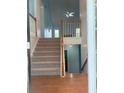 View of the staircase leading to the second floor with natural wood handrail at 571 Oak Vista Ct, Lawrenceville, GA 30044
