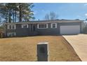 Ranch style home with gray exterior, white garage door, and well-maintained lawn at 1800 Pinedale Nw Dr, Atlanta, GA 30314