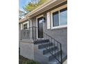 Gray brick front entry with black metal railing and dark brown door at 1800 Pinedale Nw Dr, Atlanta, GA 30314
