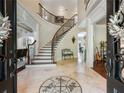 Elegant two-story entryway with a curved staircase and mosaic flooring at 1891 Prospect Church Rd, Lawrenceville, GA 30043