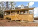 Green house with a wrap-around porch and wood deck at 44 Browns Ct, Powder Springs, GA 30127