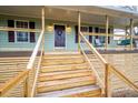Inviting front porch with wooden stairs and cable railing at 44 Browns Ct, Powder Springs, GA 30127
