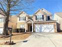 Two-story house with stone and beige exterior, a two-car garage, and a landscaped yard at 585 Briarhurst Ct, Lawrenceville, GA 30046