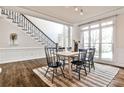 This formal dining room features hardwood floors with an adjacent staircase and large windows at 6355 Indian Acres Trl, Tucker, GA 30084