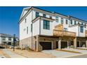 Rear view of townhome with private deck and two-car garage at 601 Millcroft Blvd, Buford, GA 30518