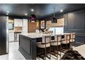 Kitchen island featuring marble countertop, seating, designer pendant lights, and modern accents at 1388 Willow Sw Trl, Atlanta, GA 30311