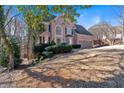 Two-story house on a sloped lot with lush landscaping at 820 Hillcrest Ln, Woodstock, GA 30189