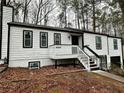 Two-story house with white siding, black accents, and a deck at 7035 Stone Wood Nw Dr, Kennesaw, GA 30152