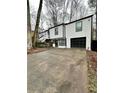 Two-story house with white siding, black accents, and a paved driveway at 7035 Stone Wood Nw Dr, Kennesaw, GA 30152