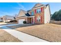 Two-story brick home with a red door and attached garage at 1170 Rose Terrace Cir, Loganville, GA 30052