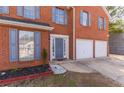 House entrance with blue door and double garage at 3886 Cedar Trace Ln, Ellenwood, GA 30294