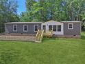 Gray and white single-wide manufactured home with wooden deck and steps at 248 Billy Bullock Rd, Dallas, GA 30157