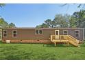 Brown single-wide manufactured home with wooden deck and steps at 248 Billy Bullock Rd, Dallas, GA 30157