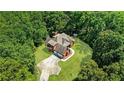 An aerial view of a secluded home surrounded by lush trees and a sprawling green lawn at 6020 Cochran Mill Rd, Chattahoochee Hills, GA 30268