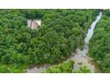 A lush, green forest surrounds this secluded property with a river flowing alongside, offering privacy at 3781 Anneewakee Rd, Douglasville, GA 30135