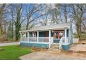 Quaint teal home with a wraparound porch and a lush green lawn at 106 Hillside Se Ave, Atlanta, GA 30315