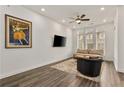 Open living room with hardwood floors, a sofa, and a large TV at 137 Devore Rd, Alpharetta, GA 30009