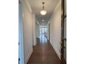 Long hallway with hardwood floors, white walls, and a view of the staircase at 5043 Baywood Ln, Woodstock, GA 30188