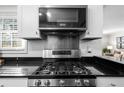 Close up on stainless steel stove and microwave appliances under bright lighting in renovated kitchen at 2732 Suwanee Se Way, Marietta, GA 30067