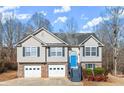 Two-story house with gray siding, two-car garage, and a blue front door at 35 Matthew Ct, Covington, GA 30016