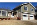 Two-story house with green siding, brick bottom, and a two-car garage at 3164 Windfield Cir, Tucker, GA 30084